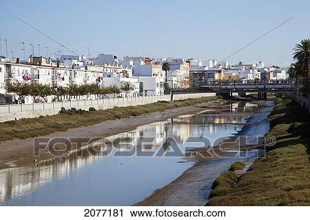 Stock Image - White Buildings Reflected In The Water; Chiclana De La Frontera Andalusia Spain. Fotosearch
