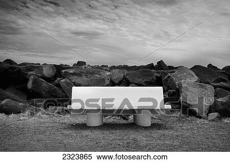 Stock Photography - White cement bench surrounded by large boulders of Cap d'Agde; Agde, France. Fotosearch