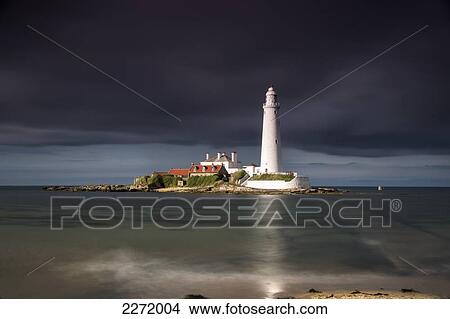 White Lighthouse Illuminated By Sunlight Under A Dark Stormy Sky; St. Mary's Island Northumberland England View Large Photo Image Picture - White Lighthouse Illuminated By Sunlight Under A Dark Stormy Sky; St. Mary's Island Northumberland England. Fotosearch