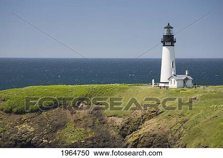 Stock Image - White Lighthouse On The Ocean With Blue Sky; Newport Oregon United States Of America. Fotosearch