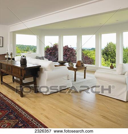 Stock Photo - White living room with window view of treetops; Victoria vancouver island british columbia. Fotosearch