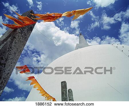 Stock Image - White Stupa Of Ruwanveliseya Dagoba With Orange Prayer Flags. Fotosearch