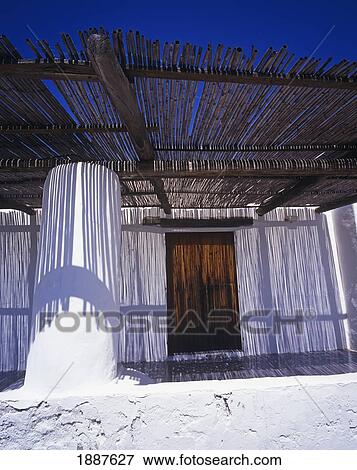 Stock Photo - White Washed House And Grass Pergola. Fotosearch