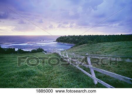 Stock Image - White Wooden Fence Leading Down To The Sea. Fotosearch
