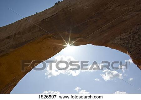 Stock Photo - Wilson Arch, Utah, Usa; Sunlight Through Arch Of Rock Formation. Fotosearch
