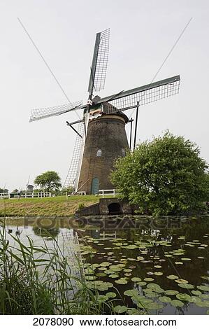 Windmill, Built Around 1740 To Drain The Excess Water From The Alblasserwaard Polders, Reflected In Nieuwe Waterschap, Kinderdijk, Netherlands View Large Photo Image Stock Image - Windmill, Built Around 1740 To Drain The Excess Water From The Alblasserwaard Polders, Reflected In Nieuwe Waterschap, Kinderdijk, Netherlands. Fotosearch