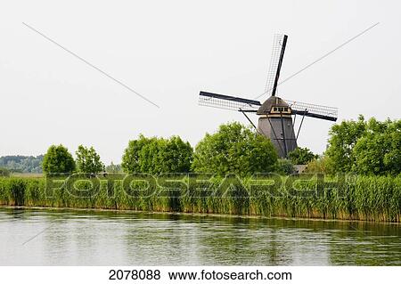 Windmill, Built Around 1740 To Drain The Excess Water From The Alblasserwaard Polders, Reflected In Nieuwe Waterschap, Kinderdijk, Netherlands View Large Photo Image Stock Photo - Windmill, Built Around 1740 To Drain The Excess Water From The Alblasserwaard Polders, Reflected In Nieuwe Waterschap, Kinderdijk, Netherlands. Fotosearch