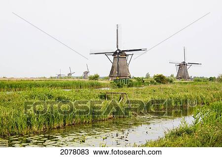 Stock Image - Windmills, Built Around 1740 Along Nieuwe Waterschap To Drain The Excess Water From The Alblasserwaard Polders, Kinderdijk, Netherlands. Fotosearch