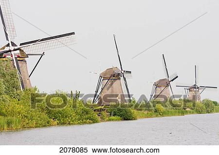 Windmills, Built Around 1740 Along Nieuwe Waterschap To Drain The Excess Water From The Alblasserwaard Polders, Kinderdijk, Netherlands View Large Photo Image Stock Photography - Windmills, Built Around 1740 Along Nieuwe Waterschap To Drain The Excess Water From The Alblasserwaard Polders, Kinderdijk, Netherlands. Fotosearch