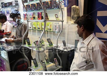 Window shopping and checking out the latest mobile phones; Mumbai, Maharashtra State, India View Large Photo Image Stock Photo - Window shopping and checking out the latest mobile phones; Mumbai, Maharashtra State, India. Fotosearch
