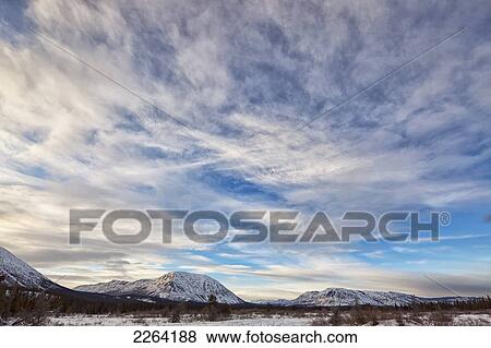 Stock Photo - Winter scene with late afternoon clouds over the annie lake road; whitehorse yukon canada. Fotosearch