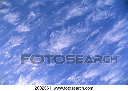 Stock Image - Wispy Clouds Over Pale Blue Skies. Fotosearch