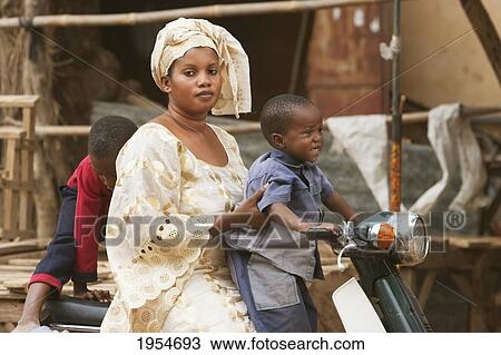 Woman and boy on a motorcycle in Segou, Mali View Large Photo Image Stock Image - Woman and boy on a motorcycle in Segou, Mali. Fotosearch
