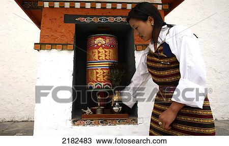 Stock Image - Woman And Prayer Wheel, Thimphu, Bhutan. Fotosearch