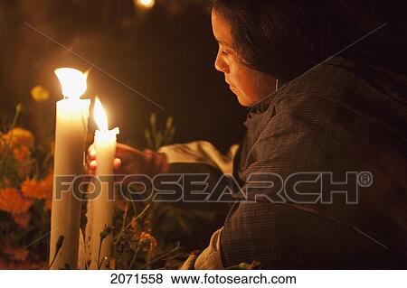 Stock Photo - Woman Arranging Candles On A Grave During The Celebration Of D. Fotosearch