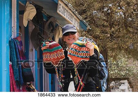 Stock Image - Woman Buying Woolen Hats From Gift Shop. Fotosearch