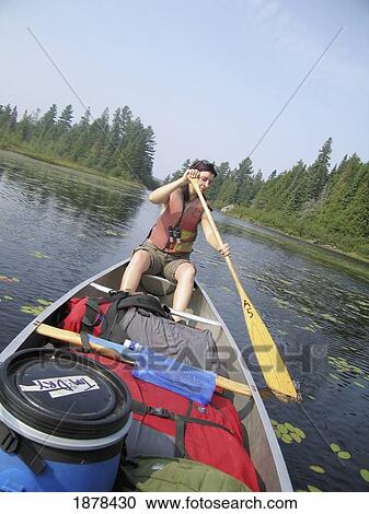 Stock Image - Woman Canoeing On A Boat In Algonquin National Park. Fotosearch