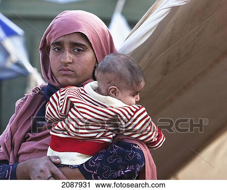 Stock Image - Woman Carrying A Baby After The 8 October 2005 Earthquake, Muzaffarabad, Azad Kashmir, Pakistan. Fotosearch