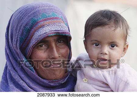 Stock Image - Woman Carrying A Baby After The 8 October 2005 Earthquake, Muzaffarabad, Azad Kashmir, Pakistan. Fotosearch