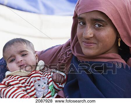 Stock Photo - Woman Carrying A Baby After The 8 October 2005 Earthquake, Muzaffarabad, Azad Kashmir, Pakistan. Fotosearch