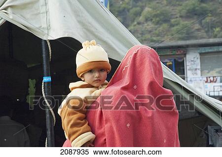 Stock Photography - Woman Carrying A Baby After The 8 October 2005 Earthquake, Muzaffarabad, Azad Kashmir, Pakistan. Fotosearch