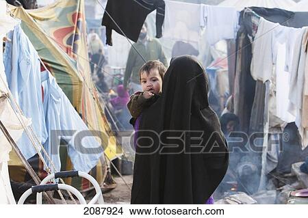 Picture - Woman Carrying A Baby In A Relief Camp After The 8 October 2005 Earthquake, Muzaffarabad, Azad Kashmir, Pakistan. Fotosearch