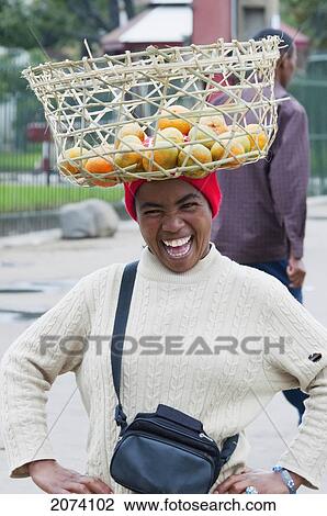 Woman Carrying A Basket With Oranges On Her Head In Antananarivo, Madagascar View Large Photo Image Stock Image - Woman Carrying A Basket With Oranges On Her Head In Antananarivo, Madagascar. Fotosearch