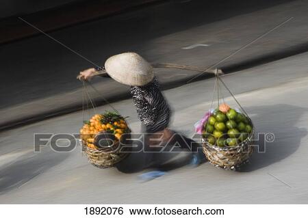 Woman Carrying Baskets Of Fruit In Street, Blurred Motion View Large Photo Image Stock Photograph - Woman Carrying Baskets Of Fruit In Street, Blurred Motion. Fotosearch
