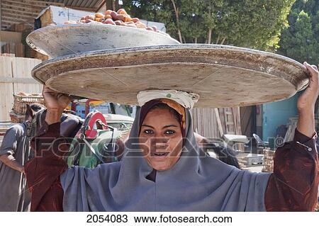 Stock Image - Woman Carrying Dates, Mansuriya, Al Jizah, Egypt. Fotosearch