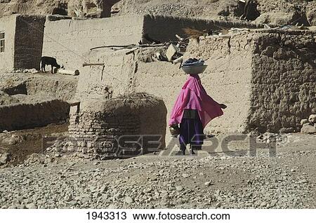 Woman Carrying Laundry On Her Head In An Aqrabat Valley Village, Bamian Province, Afghanistan View Large Photo Image Stock Image - Woman Carrying Laundry On Her Head In An Aqrabat Valley Village, Bamian Province, Afghanistan. Fotosearch