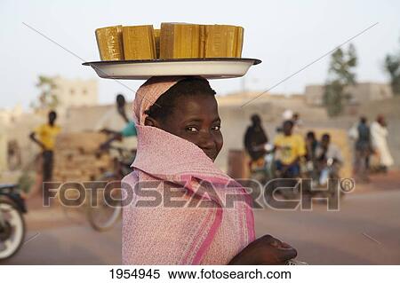 Stock Photography - Woman carrying soap bars of her head in Mopti, Mali. Fotosearch
