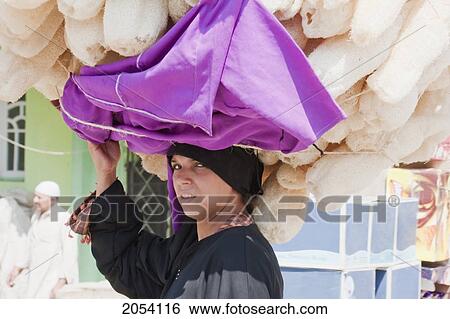 Stock Photograph - Woman Carrying Sponges On Her Head, Memphis, Al Jizah, Egypt. Fotosearch