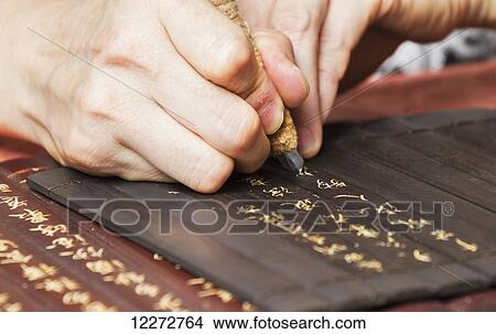 Picture - Woman carving inscriptions on wooden panels, Xidi, Anhui, China. Fotosearch