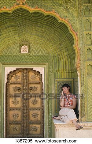 Stock Photography - Woman Chatting On Mobile Phone In Decorated Entrance Of The City Palace. Fotosearch