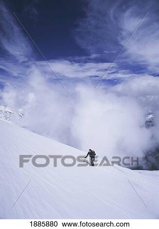 Stock Image - Woman Climbing Up Snowy Slope In The Sierra Nevada Mountains. Fotosearch