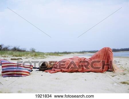 Picture - Woman Cuddles Up In A Blanket On The Beach In The Early Evening, Shelter Island, Long Island. Fotosearch