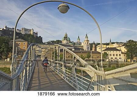 Stock Photograph - Woman Cycling Over Mozartsteg Bridge. Fotosearch