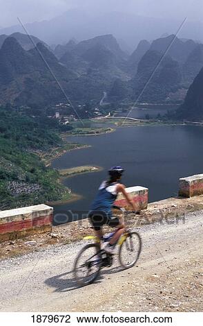 Woman Cycling With Karst Scenery In Background View Large Photo Image Stock Image - Woman Cycling With Karst Scenery In Background. Fotosearch
