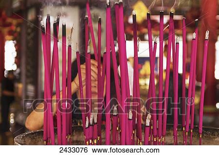 Stock Photograph - Woman depositing joss sticks in an incense burner in a Sam Pho Kong Chinese Temple, Semarang, Central Java, Indonesia. Fotosearch