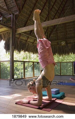 Woman Doing Hand Stand In Grass Roofed Eco Lodge View Large Photo Image Stock Photo - Woman Doing Hand Stand In Grass Roofed Eco Lodge. Fotosearch
