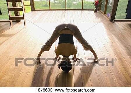 Stock Image - Woman Doing Yoga In An Eco-Lodge. Fotosearch