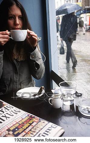 Stock Photography - Woman Drinking Coffee At Coffee Shop; London, England. Fotosearch