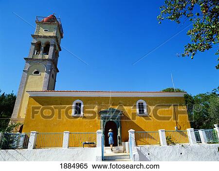 Stock Photography - Woman Entering Yellow Church. Fotosearch