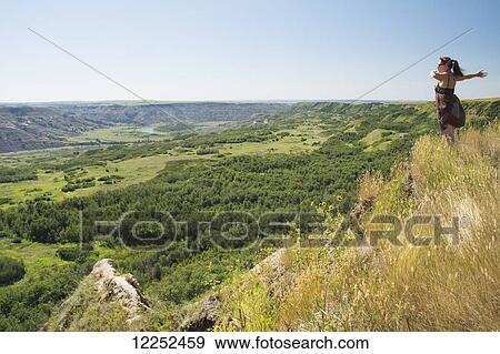 Woman enthusiastically enjoying the view of a green river valley; Alberta, Canada View Large Photo Image Stock Photo - Woman enthusiastically enjoying the view of a green river valley; Alberta, Canada. Fotosearch