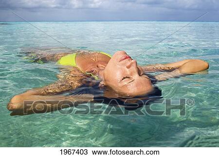 Woman Floating In Tropical Ocean Water, Close-Up Of Face. View Large Photo Image Stock Image - Woman Floating In Tropical Ocean Water, Close-Up Of Face.. Fotosearch