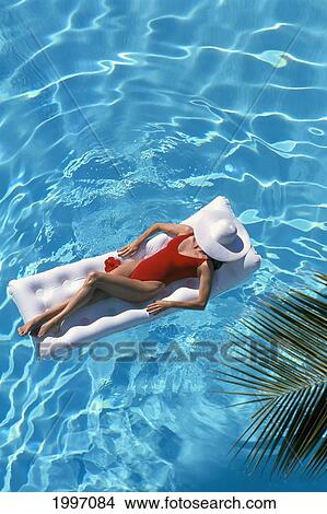 Woman Floats In Pool On Raft, White Hat A03B View Large Photo Image Picture - Woman Floats In Pool On Raft, White Hat A03B. Fotosearch