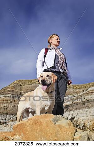 Woman Hiking With Her Yellow Labrador Retriever In The Badlands Of Drumheller, Alberta, Canada View Large Photo Image Stock Photography - Woman Hiking With Her Yellow Labrador Retriever In The Badlands Of Drumheller, Alberta, Canada. Fotosearch