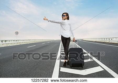 Woman hitchhiking on a highway with her luggage; Xiamen, Fujian, China View Large Photo Image Stock Image - Woman hitchhiking on a highway with her luggage; Xiamen, Fujian, China. Fotosearch