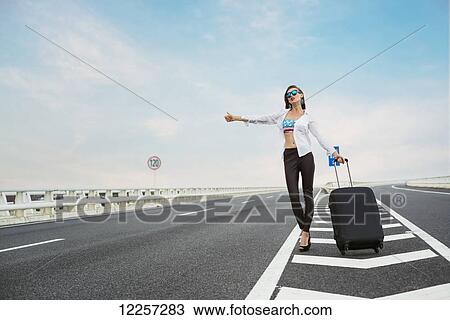 Woman hitchhiking on a highway with her luggage; Xiamen, Fujian, China View Large Photo Image Stock Image - Woman hitchhiking on a highway with her luggage; Xiamen, Fujian, China. Fotosearch