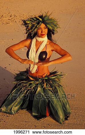 Stock Image - Woman Hula At Sunrise On Beach, Ti Leaf Skirt And Haku, Coconut Top, Shell Lei. Fotosearch